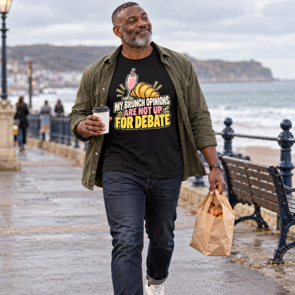 Man wearing the Cute Croissant design black t-shirt on a seaside promenade
