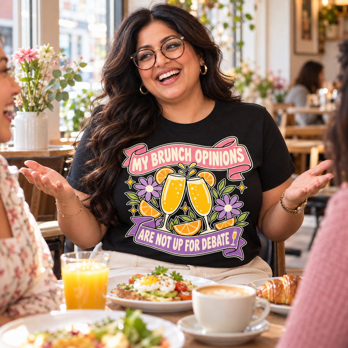 Woman wearing the Floral Banner design black t-shirt at a brunch cafe