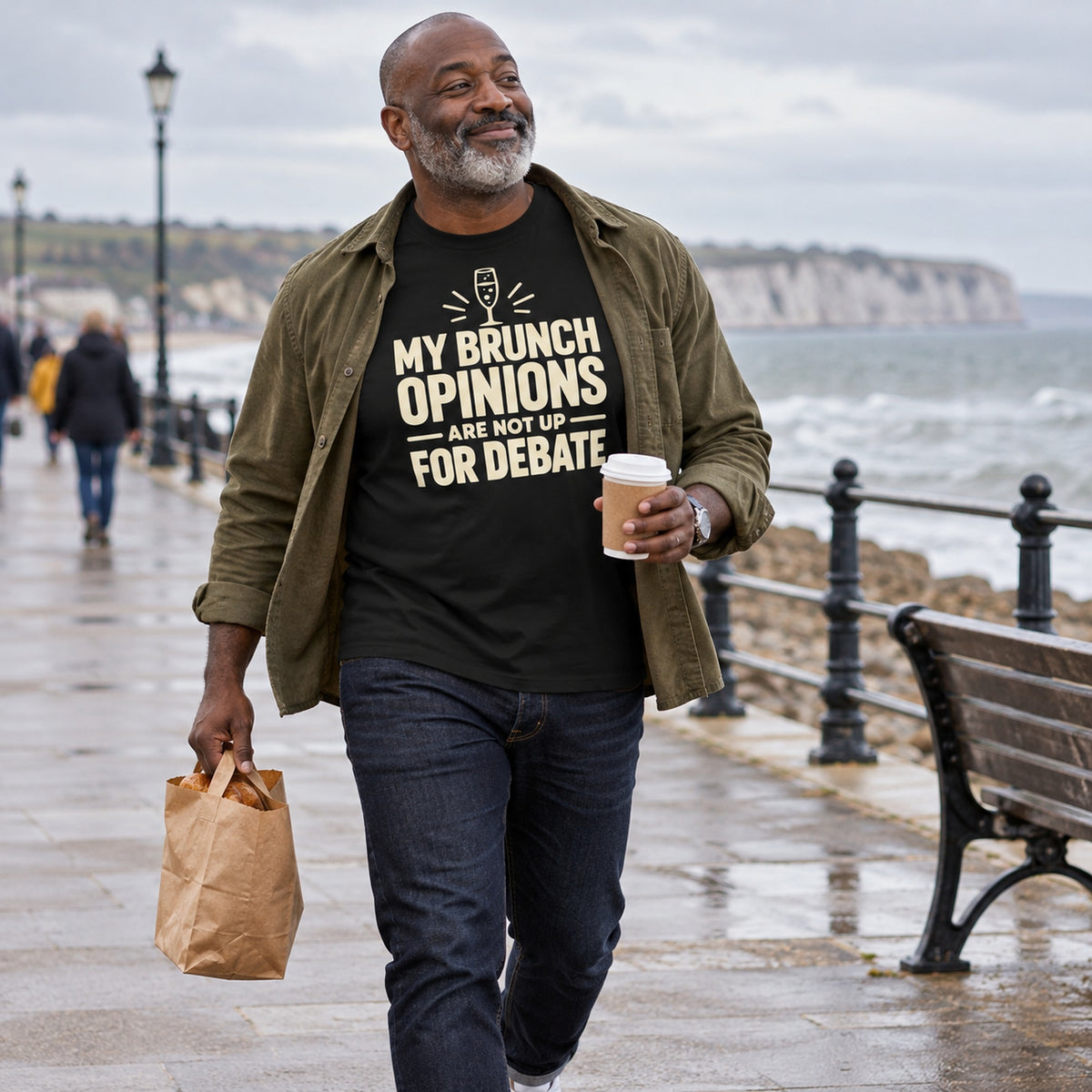 Man wearing the Minimal Type design black t-shirt on a seaside promenade
