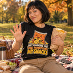 Woman wearing the Crisp Packet design black t-shirt on a picnic blanket in an autumn park