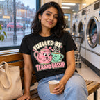 Woman wearing the Gossiping Teapots design black t-shirt in a launderette on a rainy afternoon