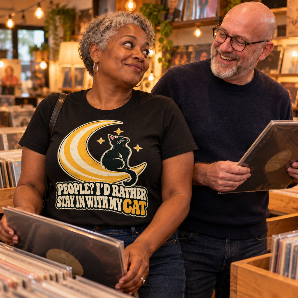 Couple in a vinyl record shop, woman wearing the Moon Cat design black t-shirt