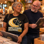 Couple in a vinyl record shop, woman wearing the Moon Cat design black t-shirt