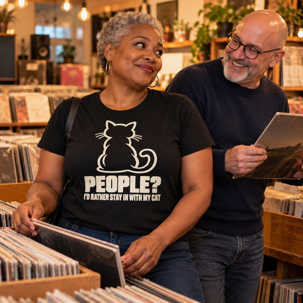 Couple in a vinyl record shop, woman wearing the Minimal Cat design black t-shirt