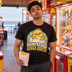 Man wearing the Retro Egg design black t-shirt in a seaside arcade holding a bag of chips