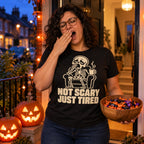 Woman wearing the Line Skeleton design black t-shirt on a front doorstep on Halloween evening holding a bowl of sweets