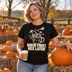 Woman wearing the Witch Hat Mug design black t-shirt at an autumn pumpkin patch holding a coffee cup