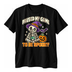 Black t-shirt with a pixel art skeleton holding a controller beside a jack o lantern above the text Paused My Game To Be Spooky