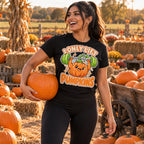 Woman wearing the Sticker Strongman Pumpkin design black t-shirt carrying a pumpkin at a pumpkin patch