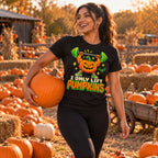 Woman wearing the Pixel Powerlifter Pumpkin design black t-shirt carrying a pumpkin at a pumpkin patch