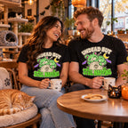 Couple wearing the Cartoon Zombie Cat Tombstone design black t-shirts at a cat cafe table with a ginger cat napping
