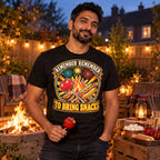 Man wearing the Retro Badge Bonfire Snacks design black t-shirt by his garden bonfire at dusk holding a toffee apple