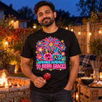Man wearing the Neon Sign Fireworks design black t-shirt by his garden bonfire at dusk holding a toffee apple