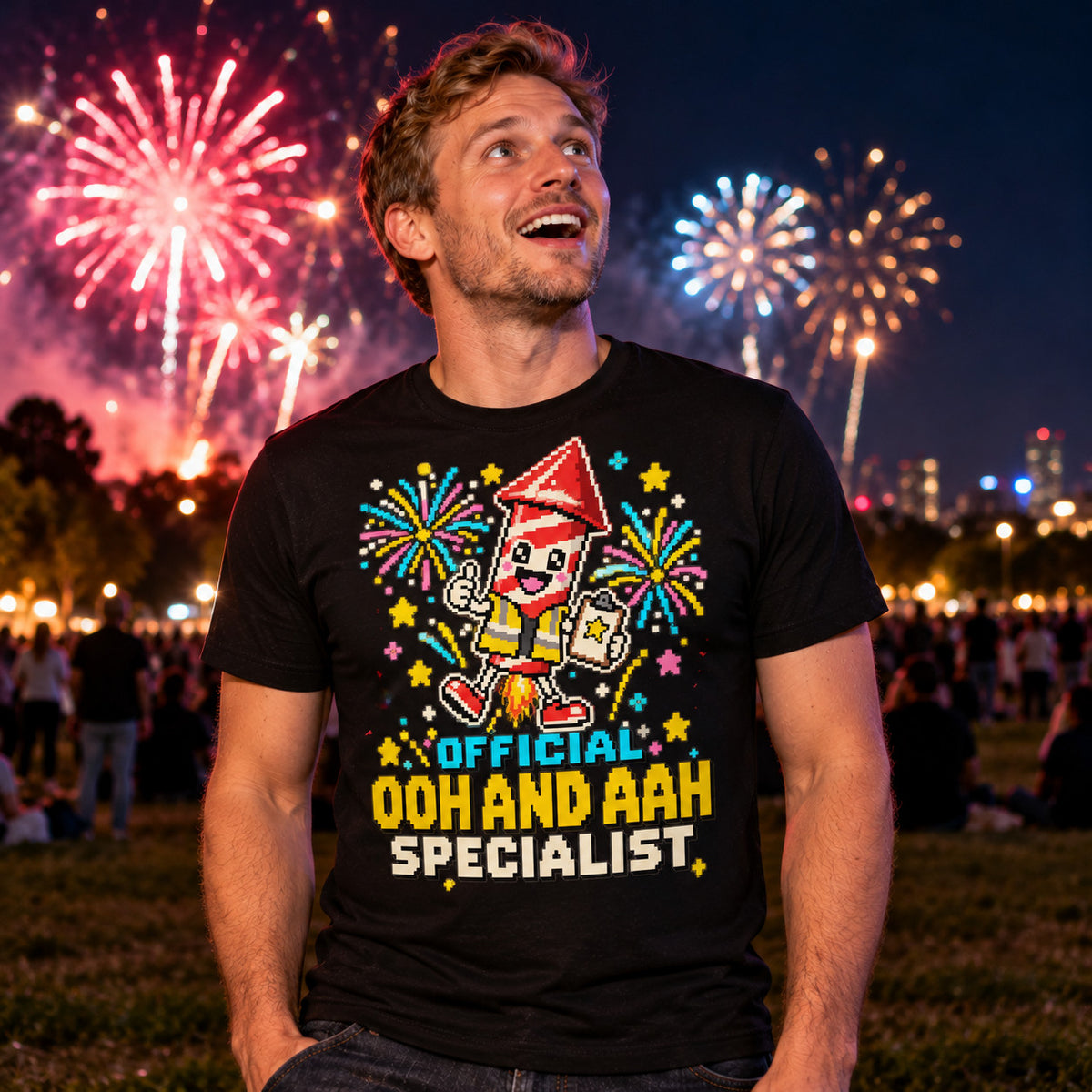 Man wearing the Pixel Rocket Specialist design black t-shirt on a park hill at night looking up at fireworks