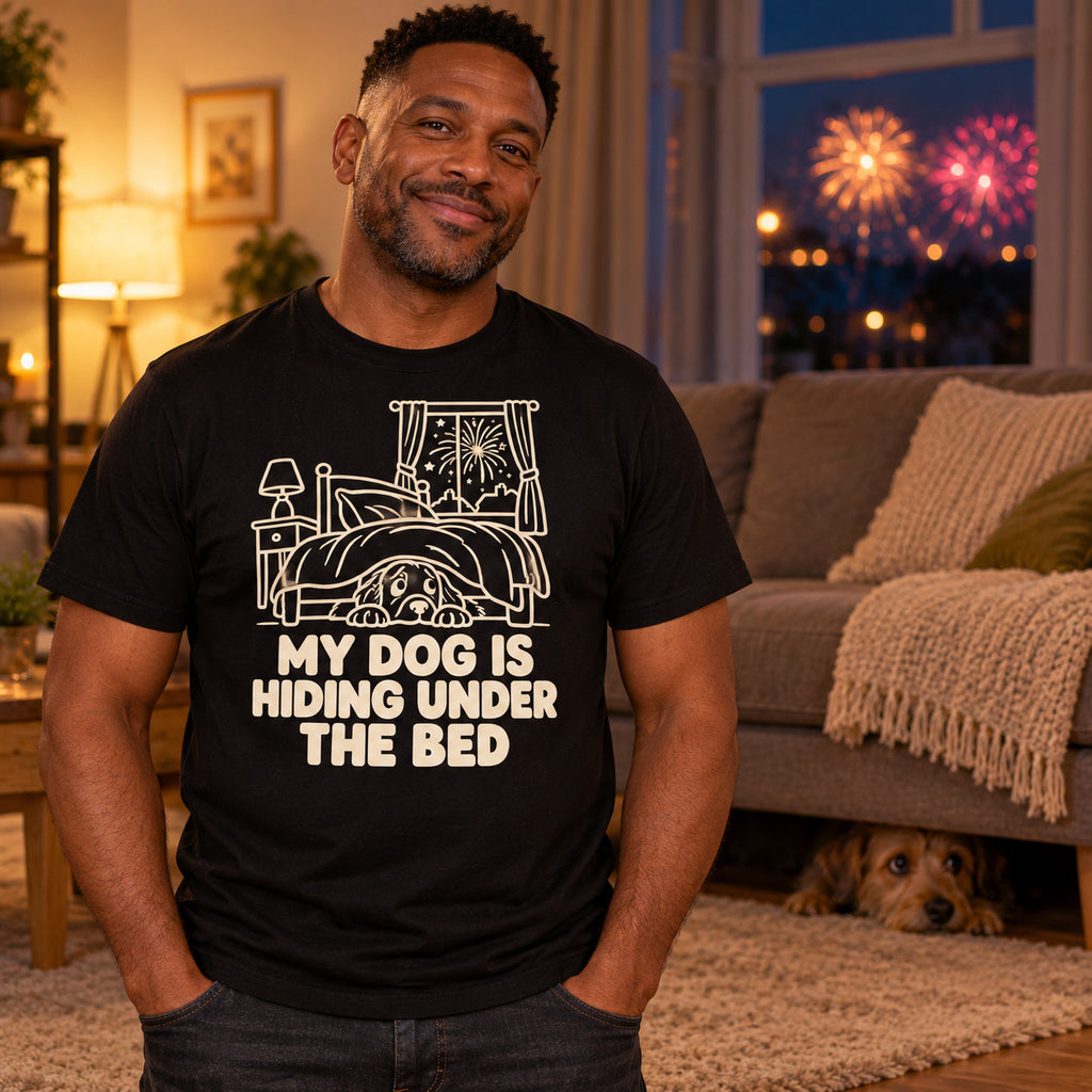 Man wearing the Line Art Pup design black t-shirt in a cosy living room at night with a worried dog peeking out from under the sofa