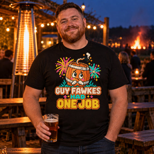 Man wearing the Pixel Barrel design black t-shirt in a pub beer garden at dusk holding a pint with a bonfire glowing behind