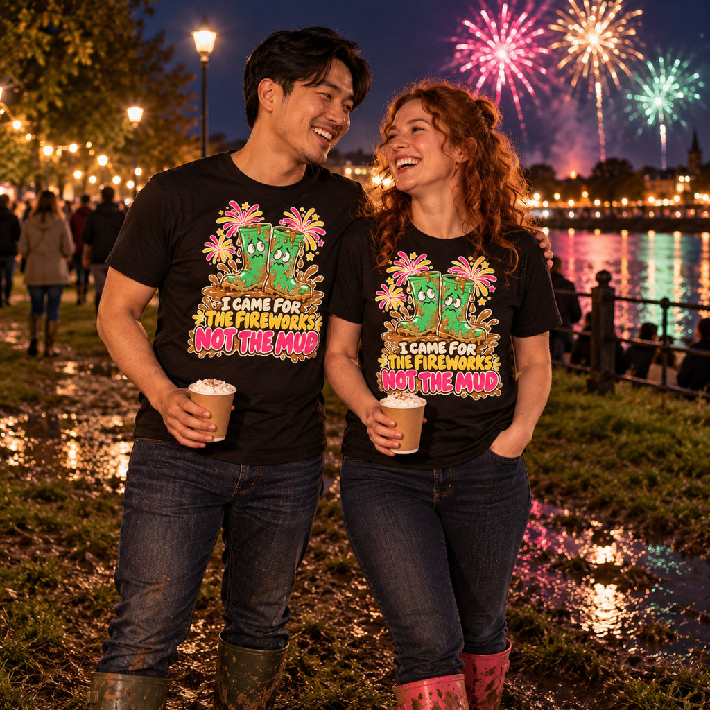 Couple wearing matching Cartoon Wellies design black t-shirts and wellington boots in a muddy riverside park at a fireworks night holding hot chocolates