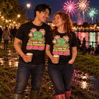 Couple wearing matching Cartoon Wellies design black t-shirts and wellington boots in a muddy riverside park at a fireworks night holding hot chocolates
