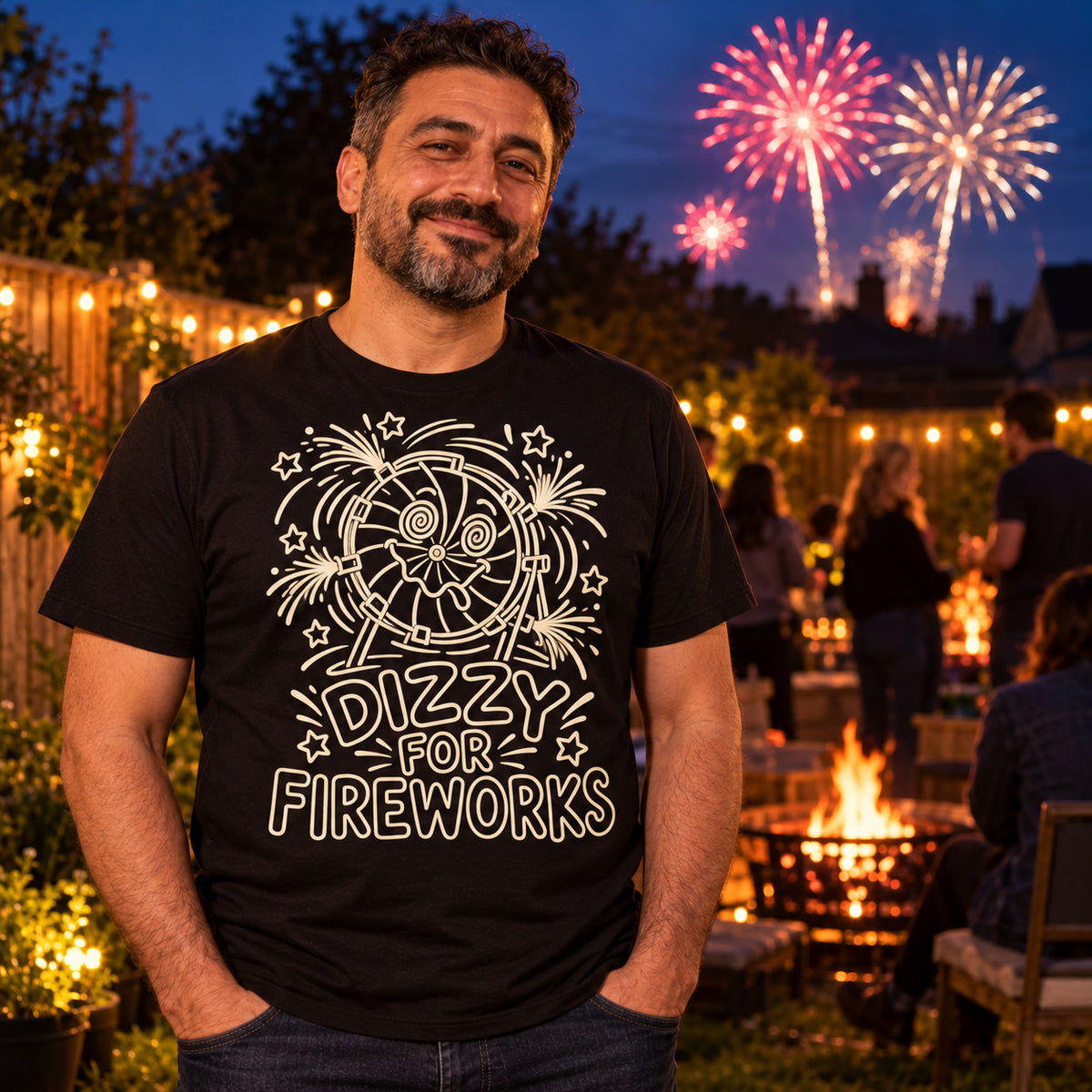 Man wearing the Line Art Wheel design black t-shirt in a UK back garden at dusk with fairy lights, a bonfire and fireworks behind