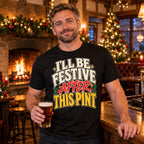 Man wearing the Bold Lettering design black t-shirt at the bar of a cosy British village pub at Christmas with an open fire