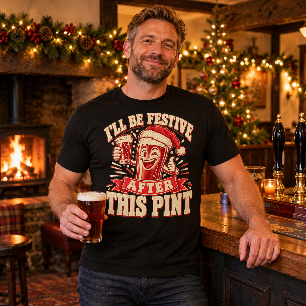 Man wearing the Woodcut Print design black t-shirt at the bar of a cosy British village pub at Christmas with an open fire