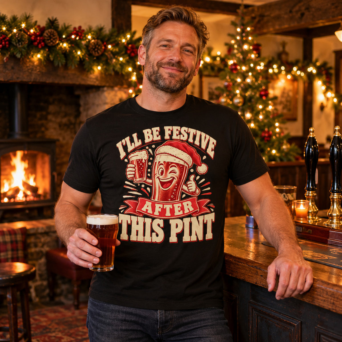 Man wearing the Woodcut Print design black t-shirt at the bar of a cosy British village pub at Christmas with an open fire