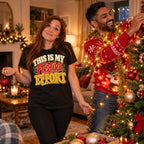 Woman wearing the Bold Type design black t-shirt holding one bauble while her partner decorates the tree at home