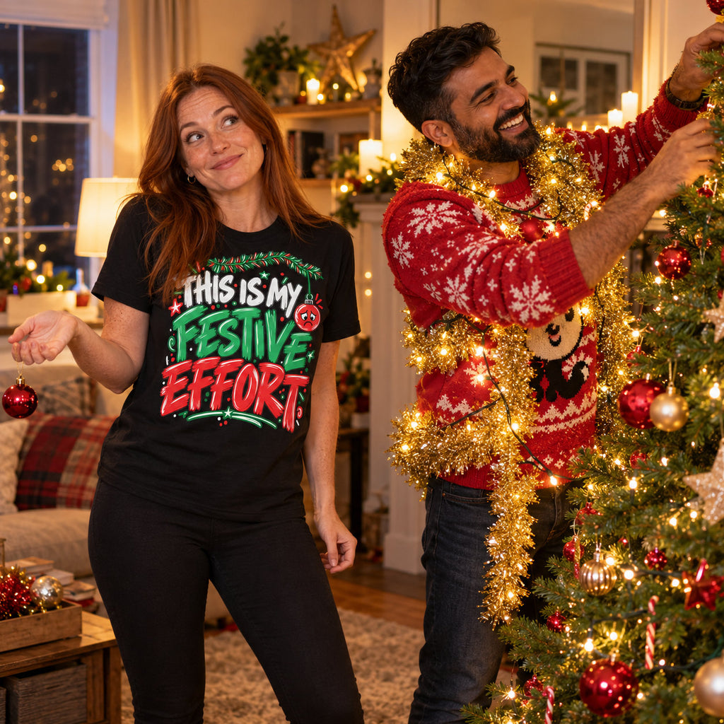 Woman wearing the Doodle Scribble design black t-shirt holding one bauble while her partner decorates the tree at home