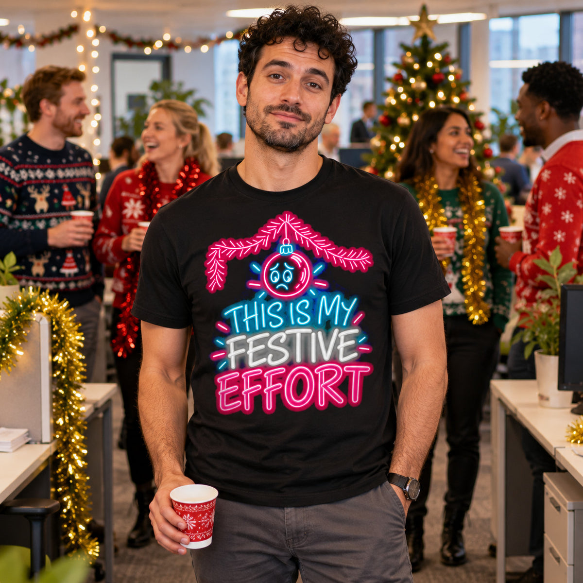 Man wearing the Neon Glow design black t-shirt at a British office Christmas party with colleagues in Christmas jumpers behind
