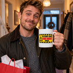 White mug with a yellow hazard warning sign reading My Secret Santa Panic Bought This, lifestyle photo 1