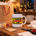 White mug with a yellow hazard warning sign reading My Secret Santa Panic Bought This, lifestyle photo 2