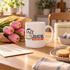 White mug with a droopy navy line drawing of a kettle and a coral tear beside the words You Left And The Kettle Was Never The Same, lifestyle photo 2