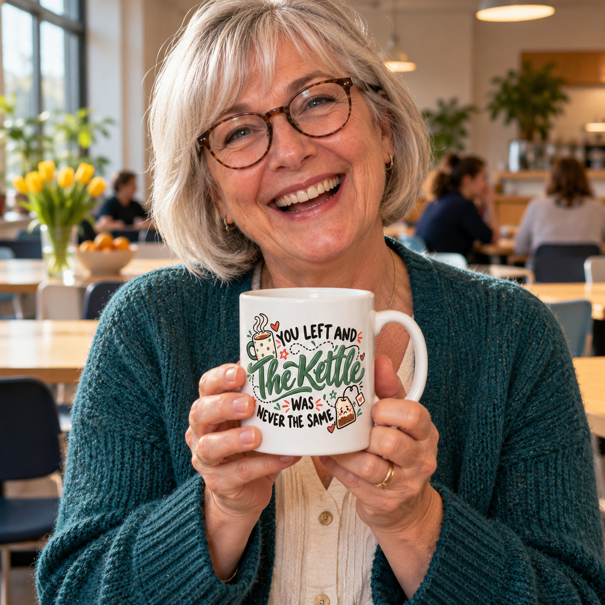 White mug with green hand lettered script, a steaming cup and a sad teabag reading You Left And The Kettle Was Never The Same, lifestyle photo 1