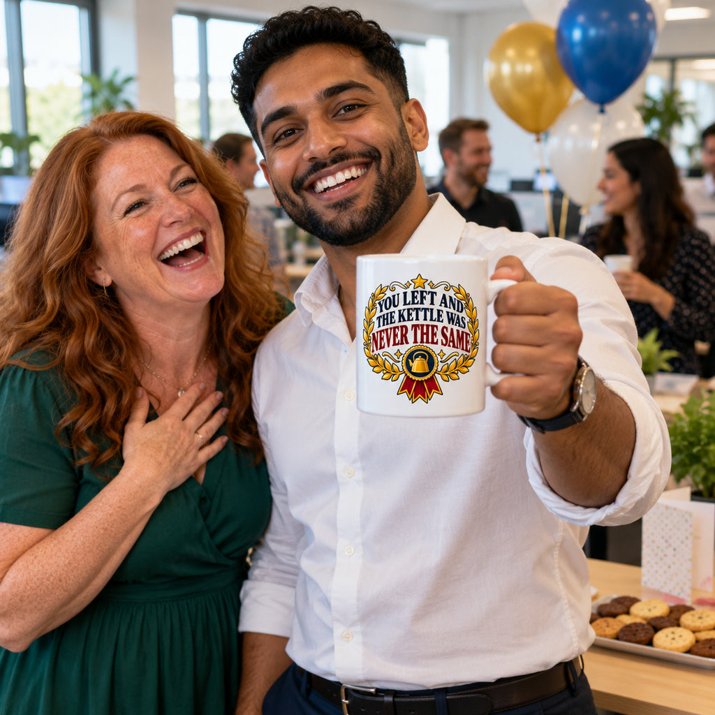 White mug with a gold laurel wreath, navy rosette and red ribbon reading You Left And The Kettle Was Never The Same, lifestyle photo 3