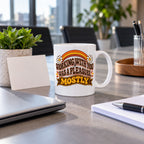 White mug with wavy brown lettering, rainbow arcs, daisies and a banner reading Working With You Was A Pleasure, Mostly, lifestyle photo 2