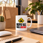 White mug with a yellow warning sign, black envelope and bold black and red text reading Reply All Was A Mistake, lifestyle photo 2