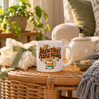 White mug with a retro striped cup, wavy orange, mustard and teal ribbons and brown groovy lettering reading Brew First, People Second, lifestyle photo 2
