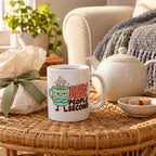 White mug with a grumpy mint cup character and coral and brown lettering reading Brew First, People Second, lifestyle photo 2